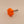 Orange star-shaped knob with a metal stem on a beige background