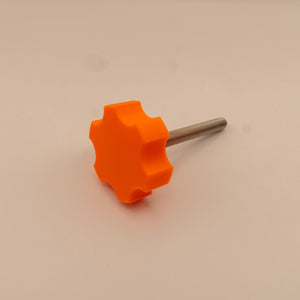 Orange star-shaped knob with a metal stem on a beige background