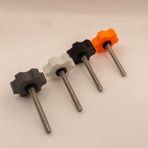 Set of four threaded rods with star-shaped knobs in different colors on a beige background