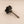 Black knob with a threaded rod on a beige background