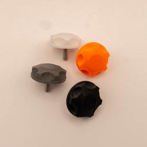 Four different colored knobs on a beige background