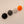 Four spherical knobs in black, gray, white, and orange on a beige background