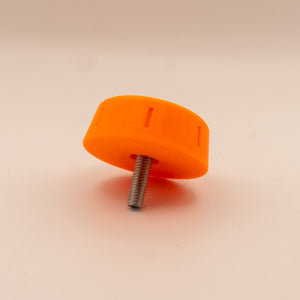 Orange plastic knob with a metal screw on a beige background