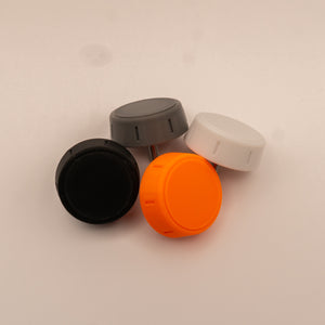 Four knobs in black, gray, orange, and white on a beige background