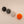 Four cylindrical knobs with black, gray, white, and orange lids on a light beige background.
