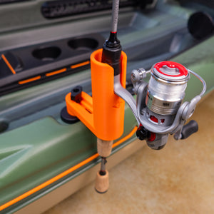 Fishing rod attached to a green kayak with an orange rod holder