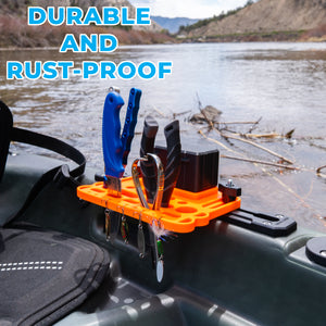 Orange kayak tool and mini tackle box holder with various tools on a kayak by a body of water