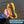 Hand holding a yellow paracord device with text about paracord length over water.