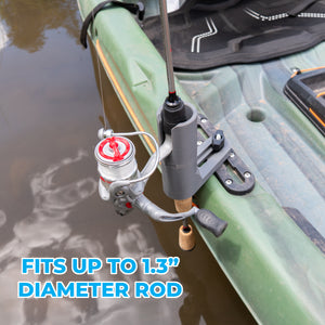 A gray kayak rod holder mounted on the side of a green kayak, holding a fishing rod with a spinning reel. Blue text overlay at the bottom reads 'FITS UP TO 1.3" DIAMETER ROD'