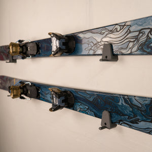 Two pairs of skis with bindings on a white background