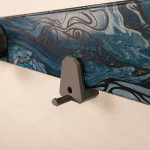 Close-up of a ski with a blue and black design and a gray ski mount.