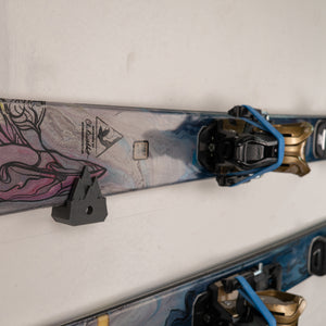 Close-up of a ski with bindings on a white surface