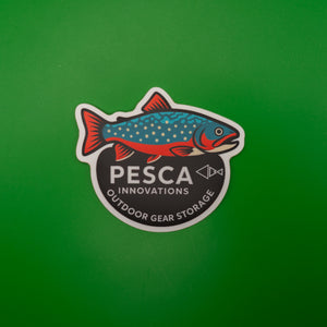 Sticker with brook trout fish design and 'PESCA Innovations' text on a green background