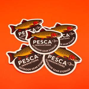 Pesca Innovations outdoor gear storage brown trout stickers on an orange background