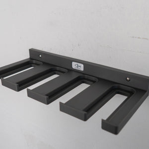 Gray wall-mounted ski pole holder with a logo on a gray background