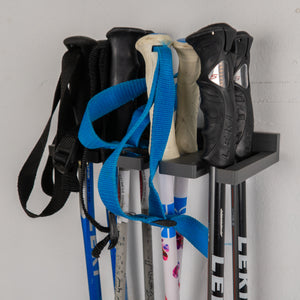 Wall-mounted ski storage rack holding multiple pairs of skis poles
