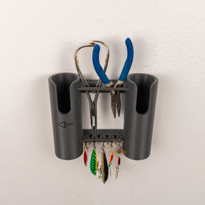 Wall-mounted fishing tool holder with pliers, scissors, and fishing lures on a white background