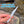 A hand holding a white rust-proof and durable nail knot tool outdoors near a stream, with blue text overlay reading 'RUST-PROOF AND DURABLE'.