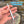 A hand holds a white plastic built-in fly threader and nail knot tool with a small metal ring at the end, set against a blurred outdoor background of flowing water and rocks. Blue text in the upper right reads 'BUILT-IN FLY THREADER'.