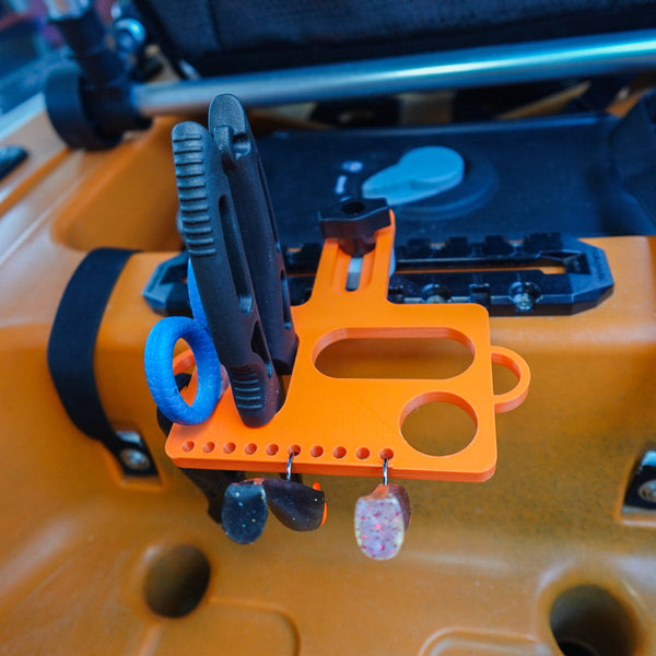 Close-up of a tool holder on a kayak's accessory rail with tools attached.