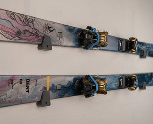 Pesca Low Profile Wall Mount Ski Holders. One pair of blue colored skis mounted horizontally on a wall.