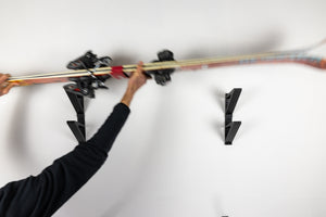 Action image of the Ski Holder Package. Easily store two sets of skis of any size on your wall. 